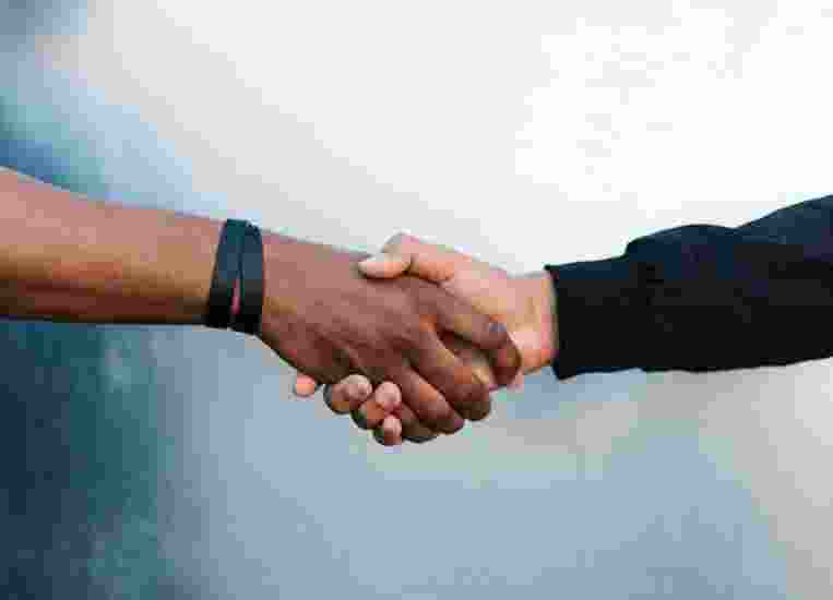 A close up image of two people shaking hands.
