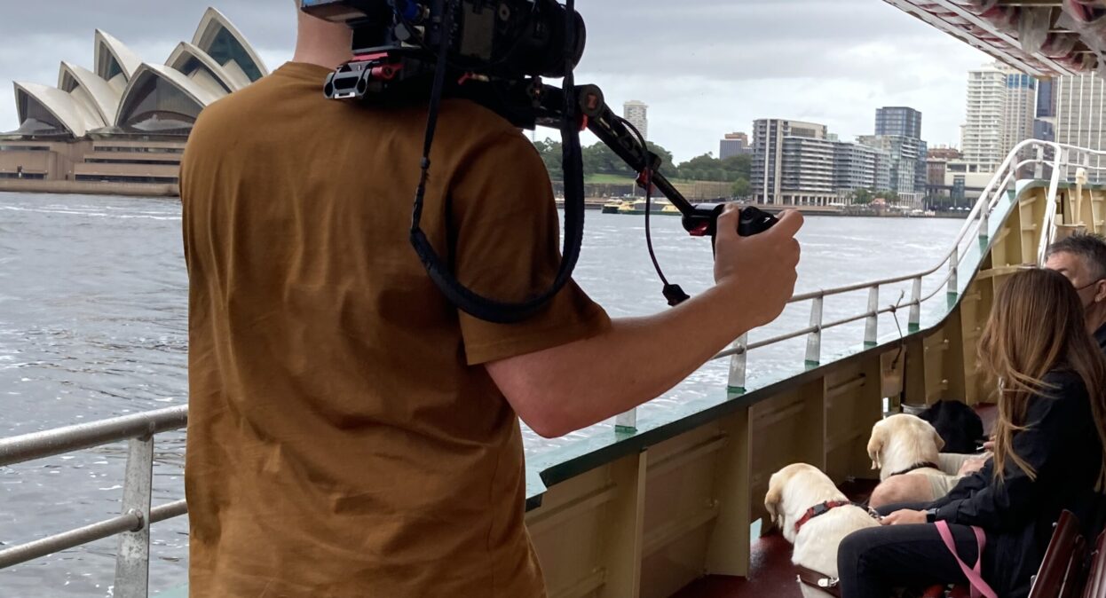 Camera crew filming in front of the Sydney Opera House